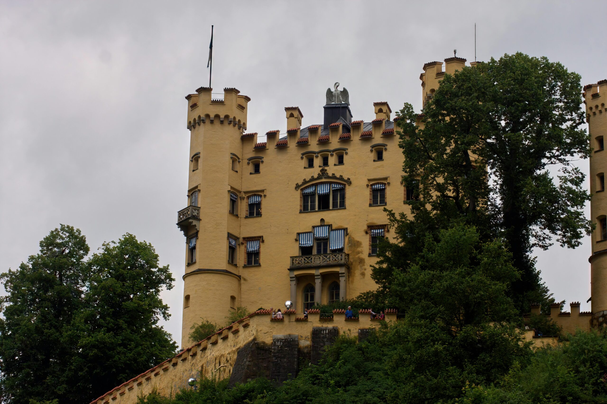 Majestic view of Hohenschwangau Castle surrounded by lush greenery in Schwangau, Bavaria.