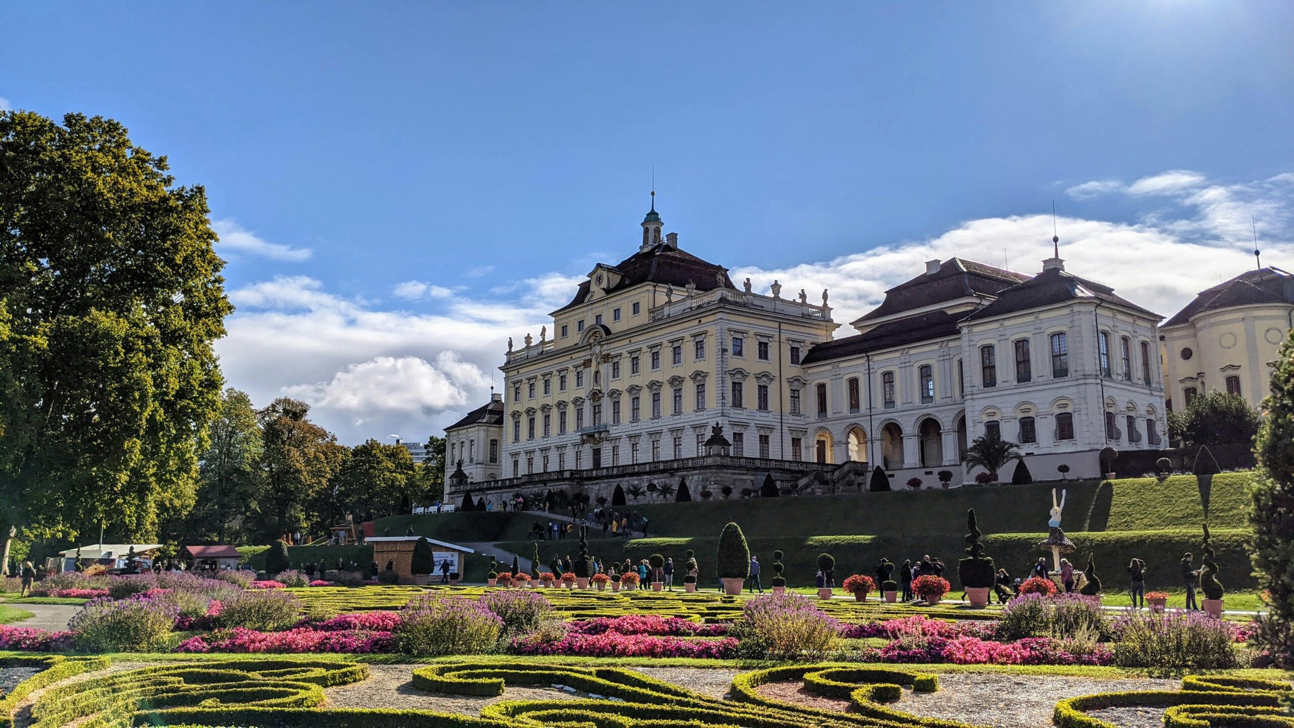 Explore the beautiful Ludwigsburg Palace surrounded by vibrant gardens on a sunny day.